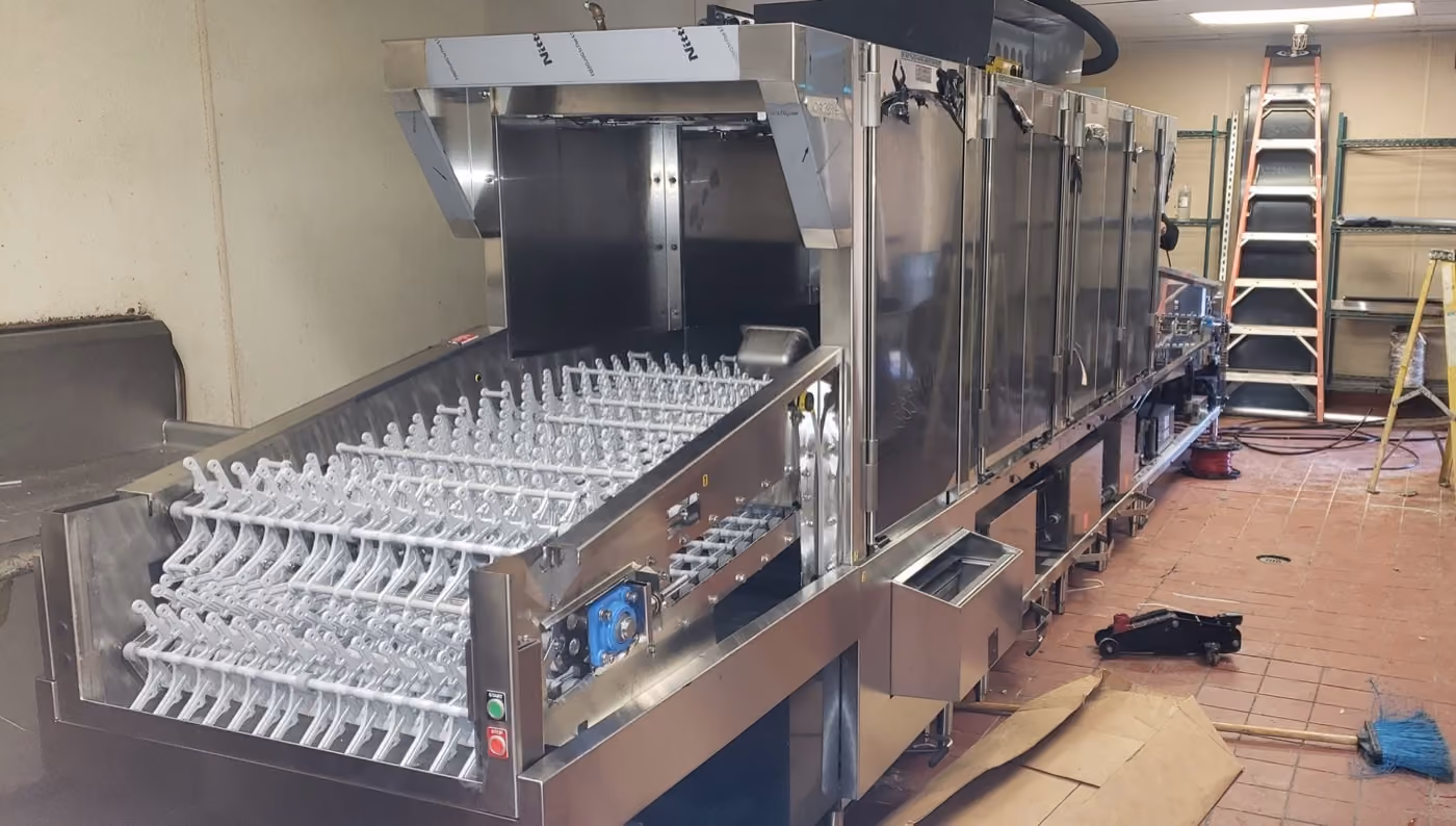 Rack conveyor dish machine with glass racks loaded, installed in a warewash line